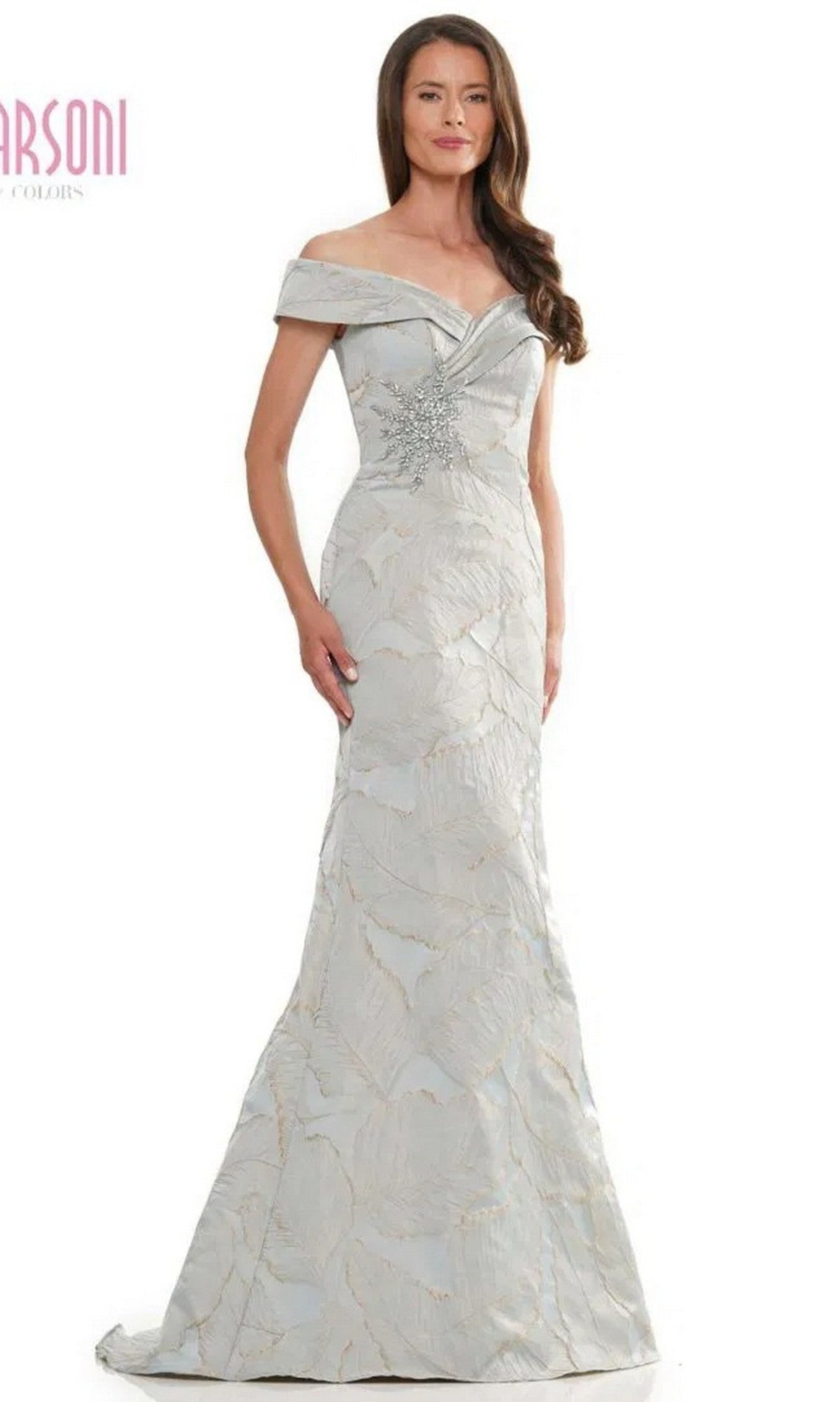 A woman wearing the Marsoni MV1266 long formal dress in light gray, featuring an off-the-shoulder design with a subtle floral pattern and beaded embellishment at the waist.